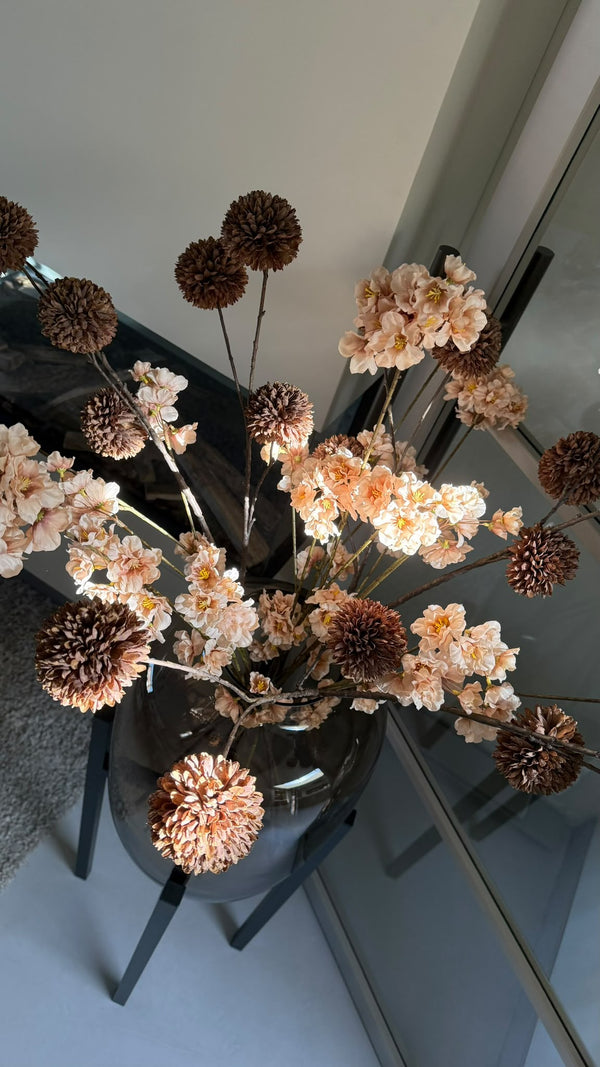 Artic XL taupe vaas Vase the World met champagne en donkerbruine kunstbloemen close up van bovenaf