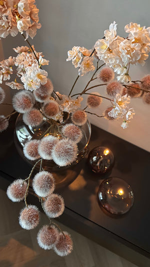 Detailfoto van een Designvaas met champagnekleurige glazen olielampjes van Peri Living op een TV meubel