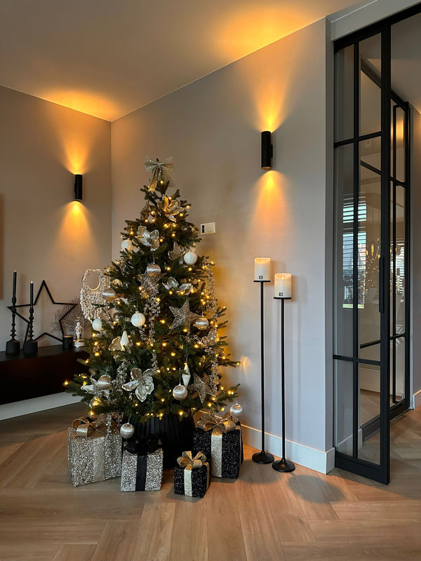 LED_Light_Candle_Rustic_White_Moveable_Flame_PTMD_op een vloerkandelaar bij_een_kerstboom en taatsdeuren