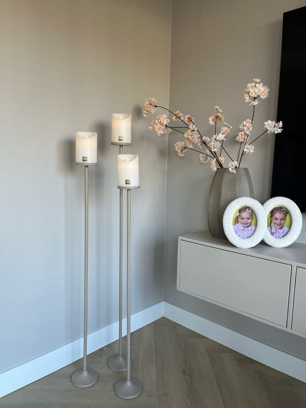 Set van 3 matbeige stalen Onah vloerkandelaren in verschillende hoogtes (100 cm, 110 cm en 120 cm) met witte PTMD LED-kaarsen.